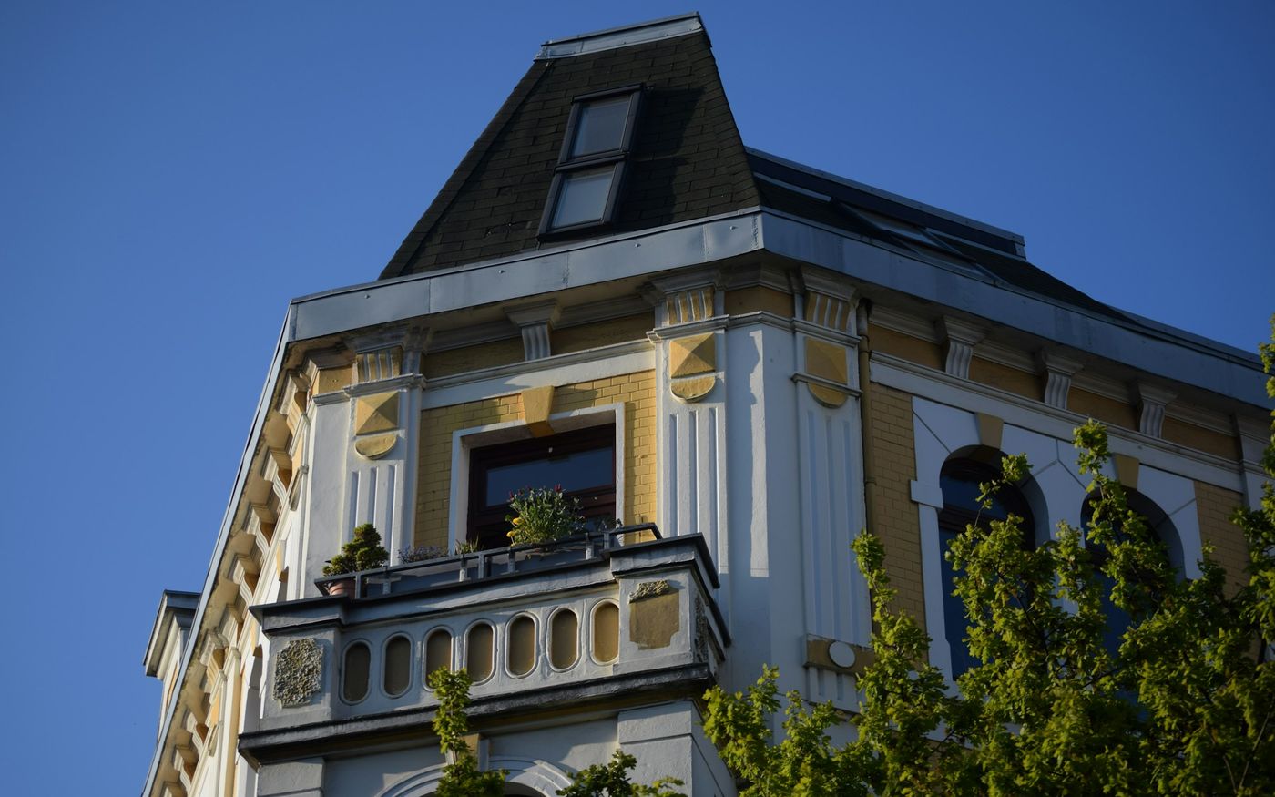 Gründerzeit-Eckhaus mit Klinkerfassade, Gesimsen und Mansarddach (Symbolbild)